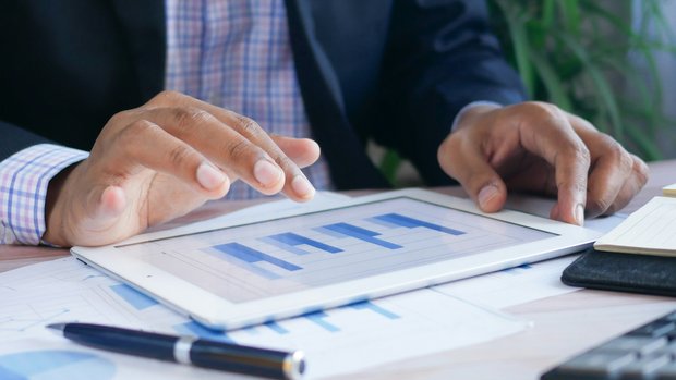 Hands reviewing a chart on a tablet
